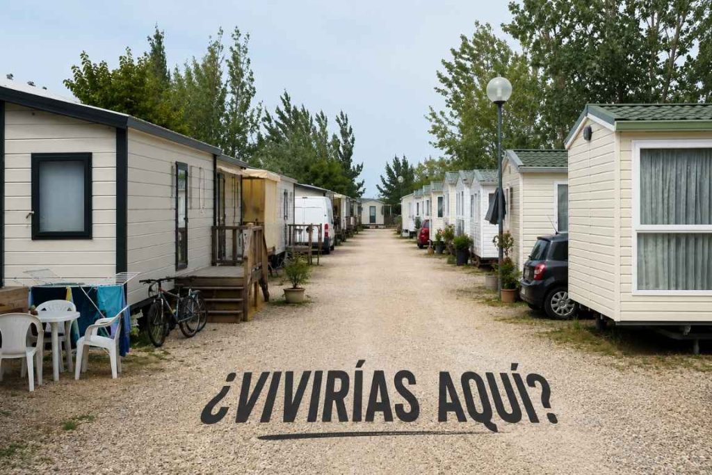 Un camping con el camino en medio con la frase vivirías aquí y casas modulares a los lados